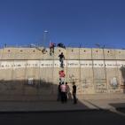 شبان يتسلقون الجدار للوصول للاقصى