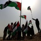 فلسطينيون يرفعون العلم الفلسطيني خلال تظاهرة ضد الاستيطان في قرية النبي صالح