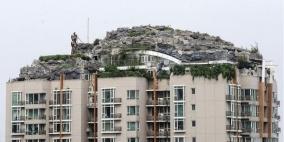 صيني نافذ يبني هضبة صخرية وفوقها فيلا على سطح عمارة