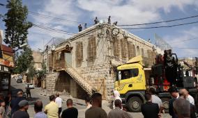 الاحتلال ينفذ أعمال بناء فوق سطح مبنى بلدية الخليل القديم المغلق منذ سنوات