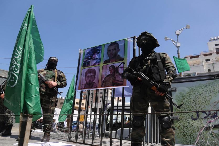 مسلحو حماس يرفعون صورا للجنود الاسرائيليين الاسرى