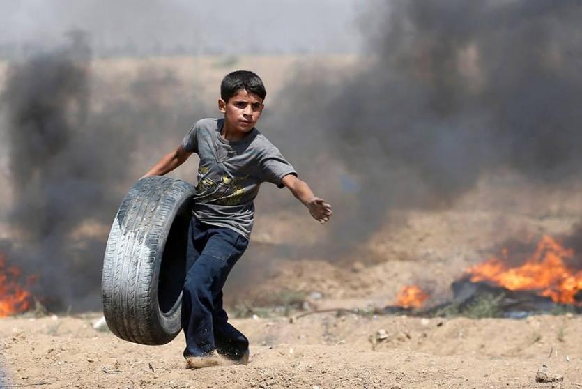 طفل يشارك في مليونية القدس بحمل الاطارات المطاطية