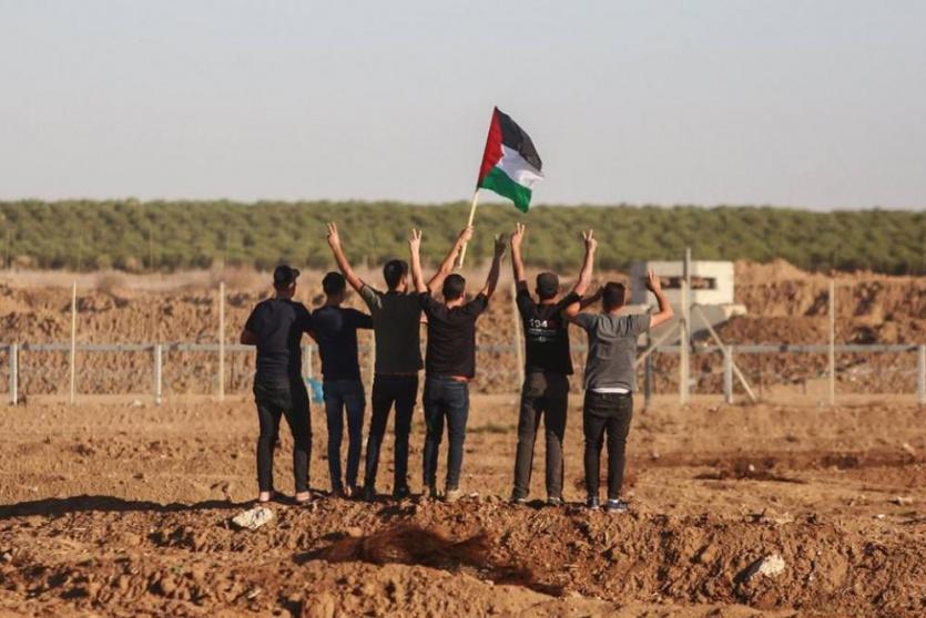 متظاهرون يقفون قرب السياج الفاصل شرق غزة