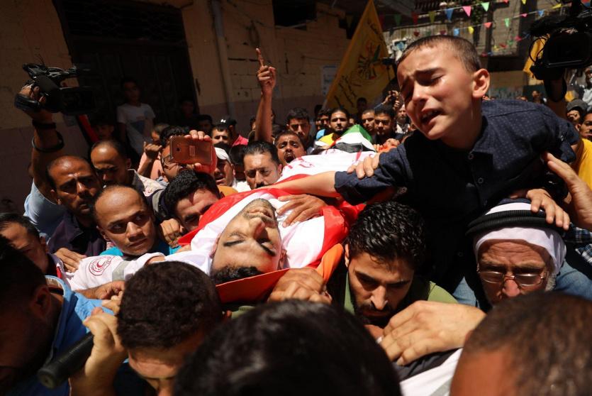 طفل الشهيد الجديلي في وداع والده- عدسة ياسر قديح