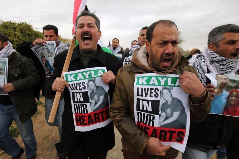 متضامنون فلسطينون يحملون صور الناشطة كايلا مولر