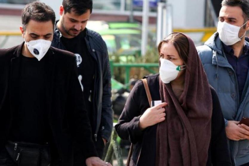 إيرانيون يرتدون كمامات