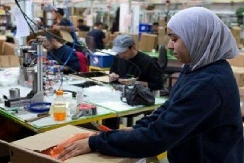 امرأة فلسطينية تعمل في أحد معامل التطريز