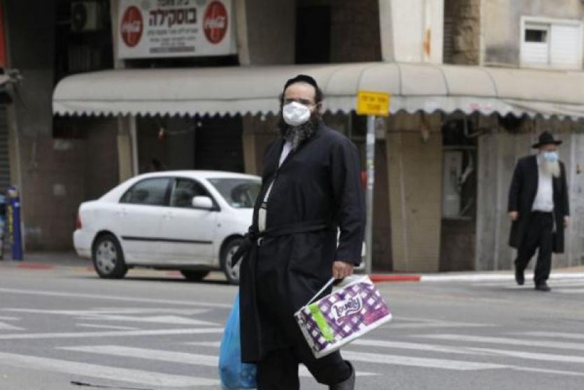 مستوطن يرتدي كمامة 