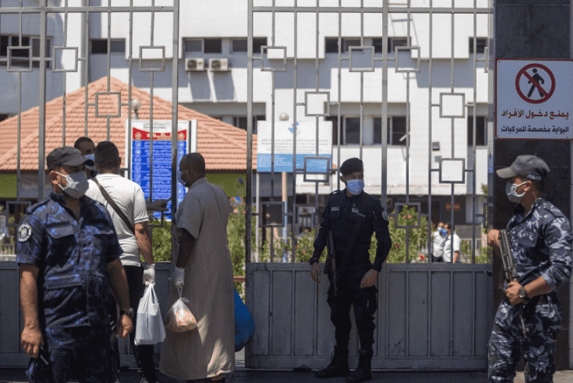مواطنون وعناصر من الشرطة يضعون كمامات في غزة