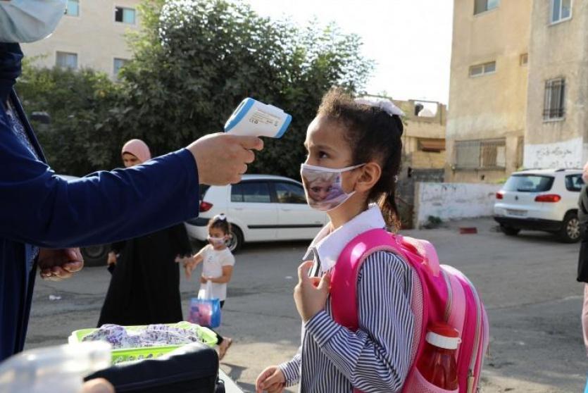 فحص درجة الحرارة لطالبة قبل دخولها المدرسة 