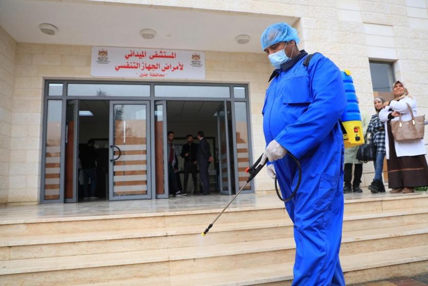 عمليات تعقيم أمام مستشفى في فلسطين