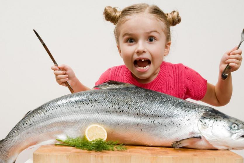 طفلة تتناول الأسماك