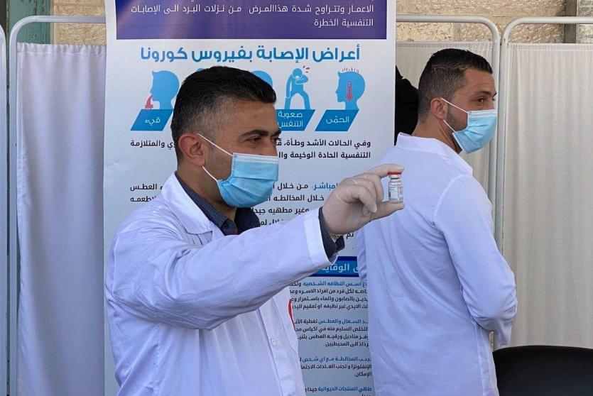 طبيب فلسطيني يحمل جرعة من اللقاح - ارشيف