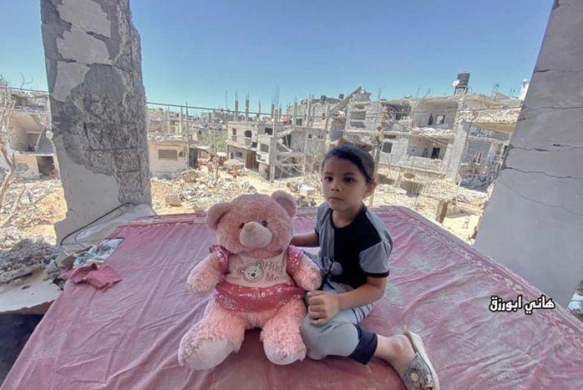طفلة تجلس على حطام منزلها المدمر من قبل الاحتلال