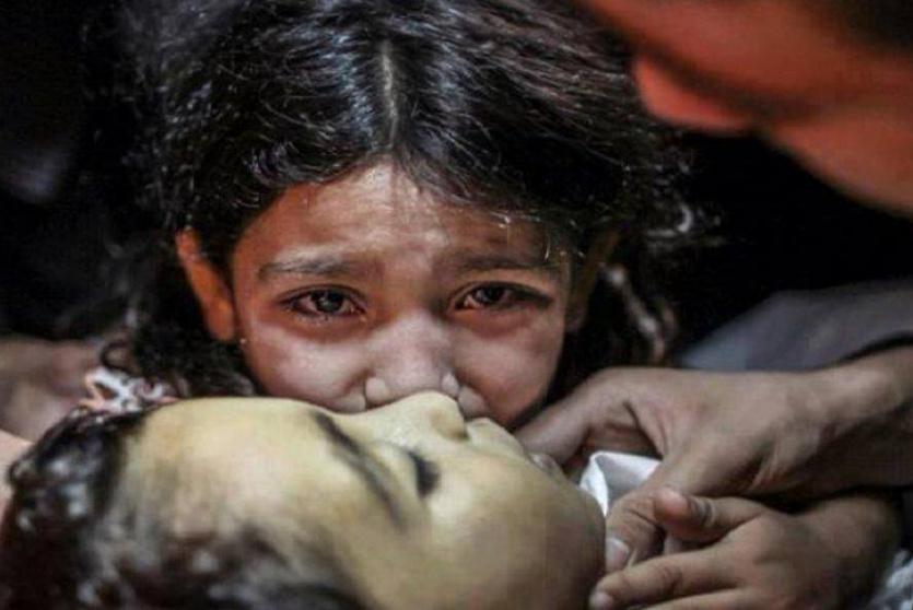 طفلة فلسطينية من غزة تبكي قرب شقيقها الذي قتله الاحتلال الإسرائيلي