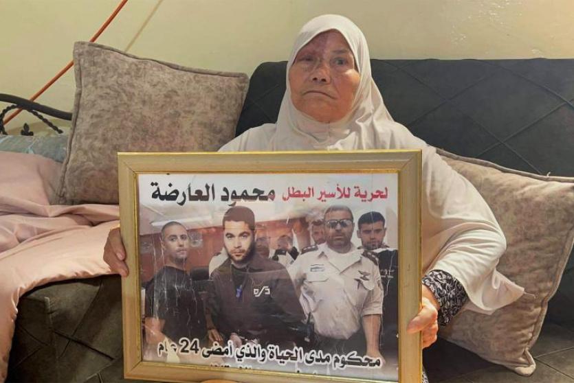 والدة الأسير محمود العارضة تحمل صورته -أرشيف-