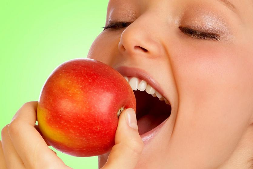فتاة تأكل تفاحة