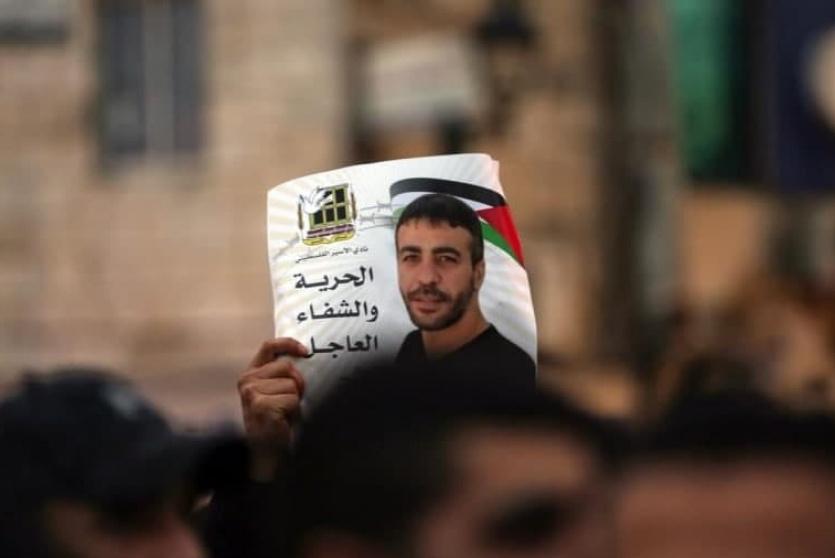 متظاهرون يرفعون صورة الأسير ناصر أبو حميد وقفة إسناد له - أرشيف