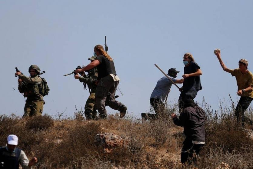 مستوطنين يعتدون على الفلسطينيين بحماية من قوات الاحتلال - أرشيف