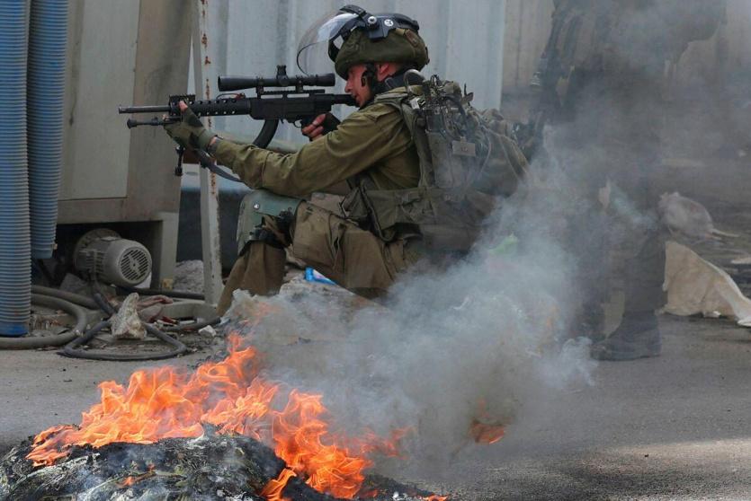 جندي إسرائيلي يطلق النار باتجاه الفلسطينيين - أرشيف