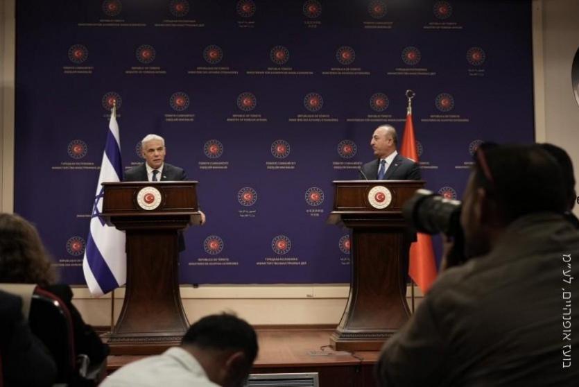 وزير الخارجية التركي مولود جاويش أوغلو مع نظيره الإسرائيلي يائير لبيد