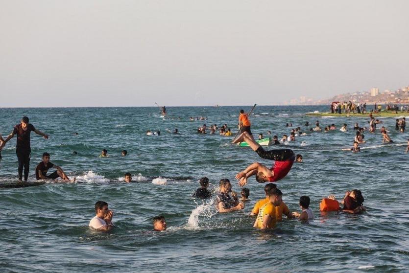مواطنون يمارسون هواية السباحة على شاطئ بحر مدينة غزة - أرشيف