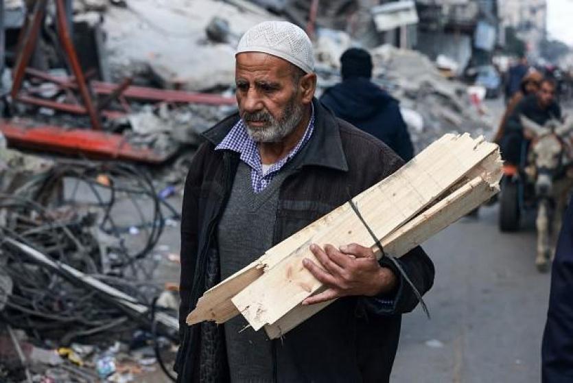 مواطن يجمع الأخشاب في غزة