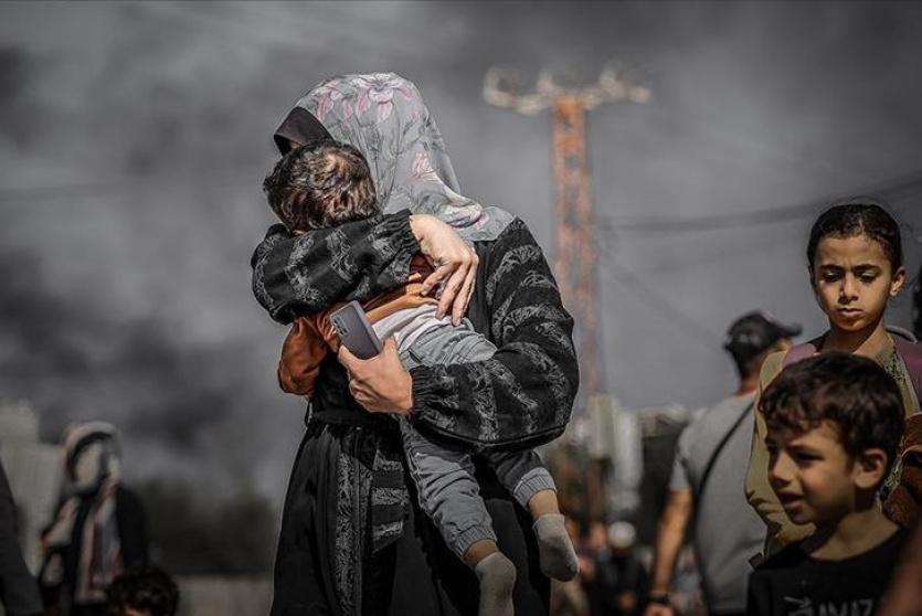 سيدة تحمي ابنها في غزة - ارشيفية
