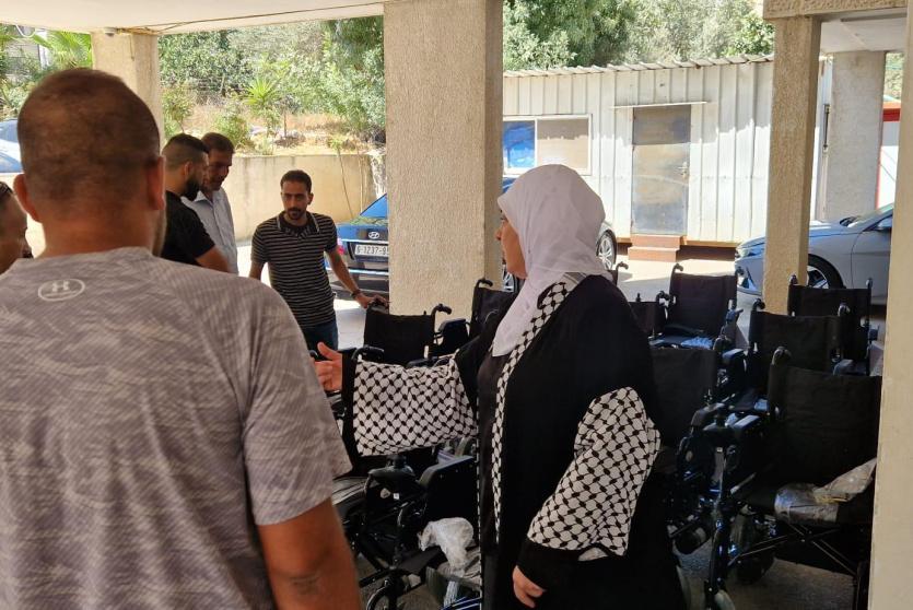 خلال تسليم د. غنام عشرات الكراسي الكهربائية لأشخاص من ذوي الإعاقة 
