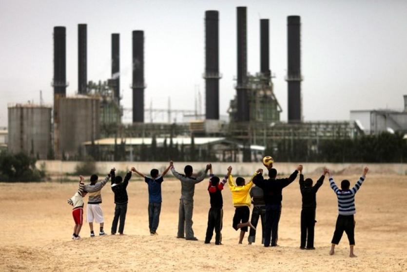 أطفال يعربون عن فرحتهم أمام محطة توليد الكهرباء بغزة
